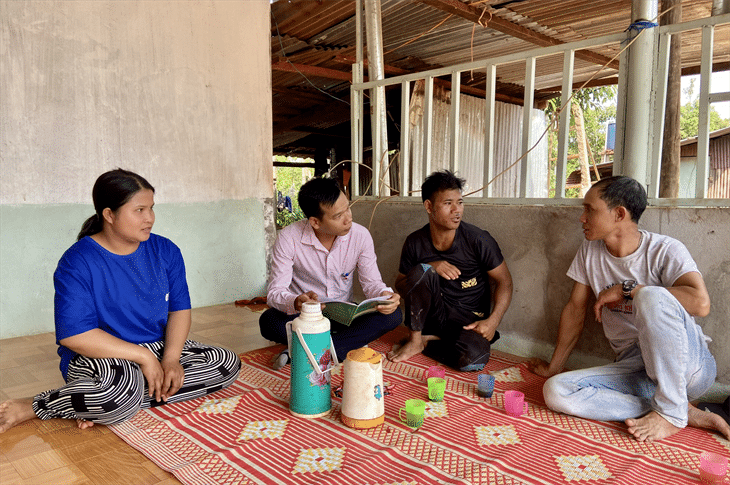 Anh Rơ Lan Hnhơn (ngoài cùng bên phải) cùng cán bộ Ngân hàng Chính sách Xã hội thăm hỏi hộ nghèo trong thôn. Ảnh: Phương Tú