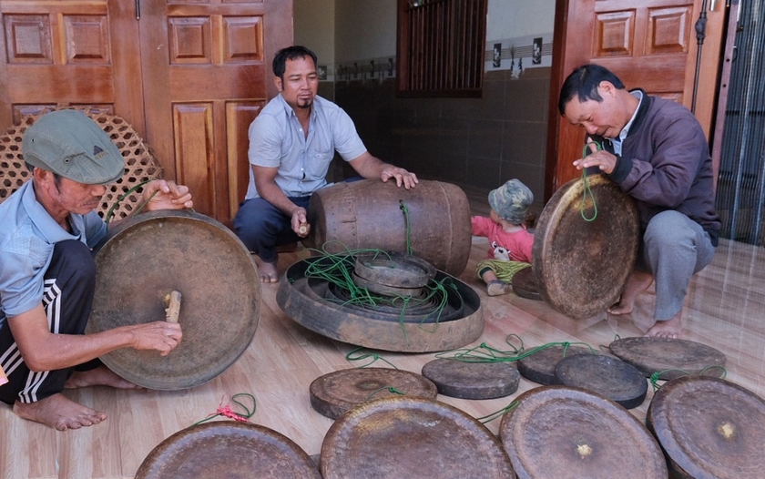 Trưởng thôn Rơh Lan Lang (bìa phải) và ông Siu Yát (bìa trái) kiểm tra bộ chiêng chuẩn bị cho các sự kiện văn hóa sắp tới. Ảnh: M.C